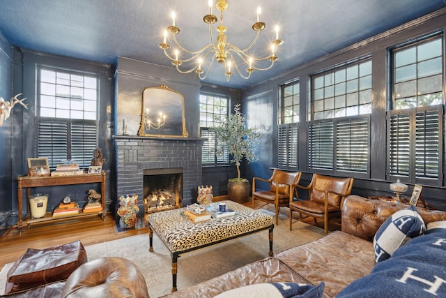 living room featuring hardwood / wood-style floors, a fireplace, and a chandelier