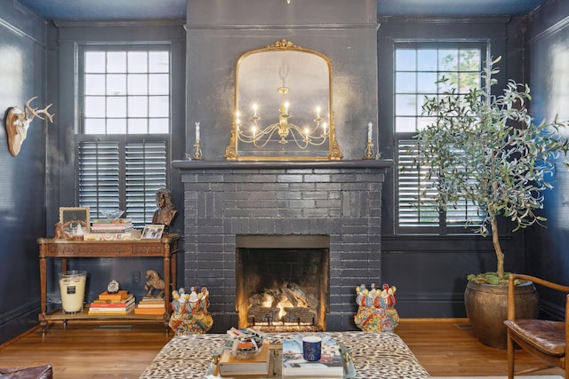 living room with a brick fireplace and wood-type flooring