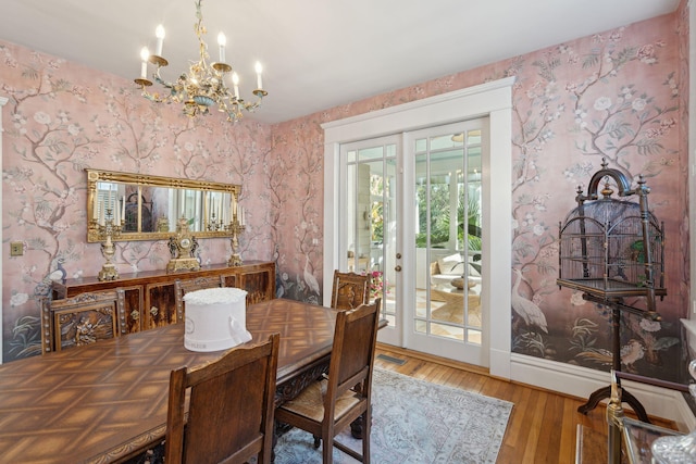 dining area with wood-type flooring and a chandelier