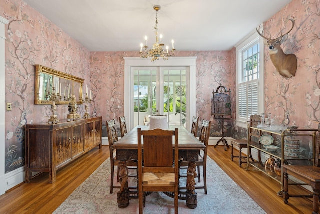 dining room featuring french doors, wood-type flooring, and a chandelier