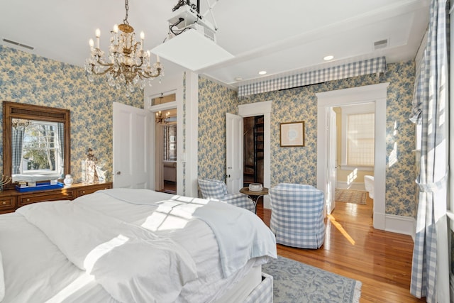 bedroom with a notable chandelier and light wood-type flooring