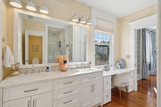 bathroom featuring vanity, hardwood / wood-style flooring, and a shower