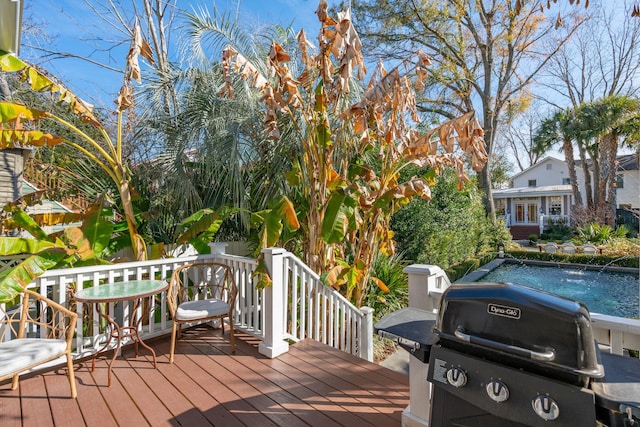 wooden deck featuring a pool and a grill