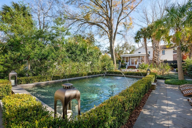 view of swimming pool with pool water feature and french doors