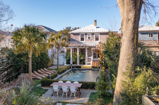 rear view of house featuring a pergola, a patio area, and pool water feature