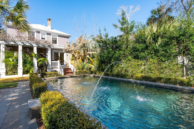 view of pool with a patio and pool water feature