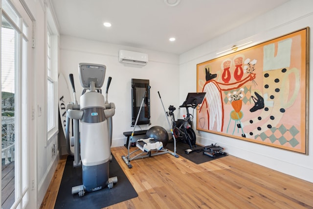 workout room with wood-type flooring and a wall unit AC