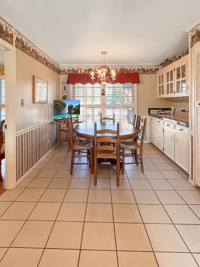 dining space featuring light tile patterned floors, a chandelier, and ornamental molding