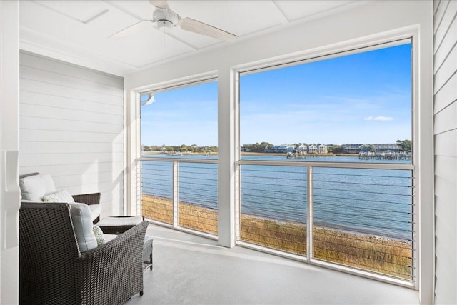 sunroom / solarium featuring a water view and ceiling fan