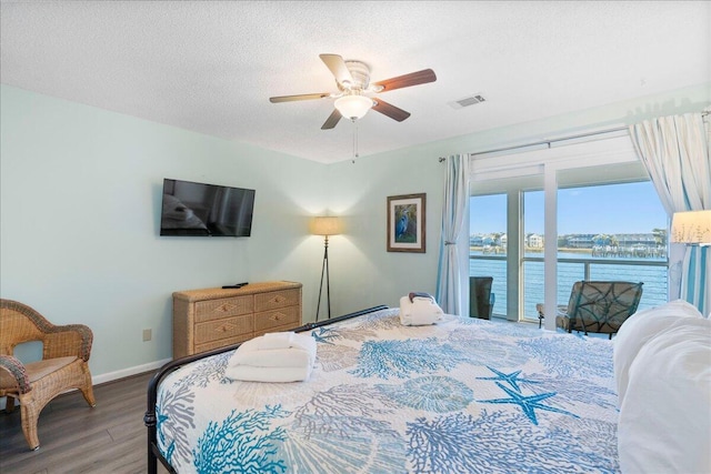 bedroom with a textured ceiling, ceiling fan, hardwood / wood-style flooring, and access to outside