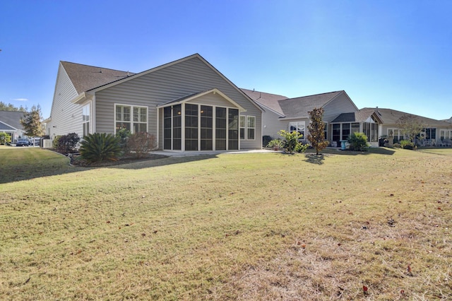 back of house with a sunroom, a yard, and a shingled roof