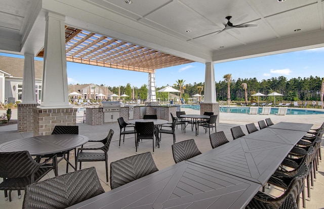 view of patio featuring a pergola, a community pool, an outdoor kitchen, ceiling fan, and outdoor dining area