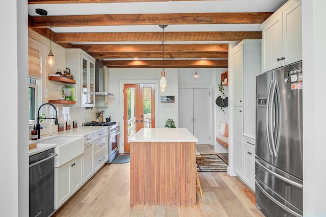 11 Francis St, Charleston, SC 29403 - kitchen with stainless steel appliances, open shelves, a sink, a kitchen island, and beamed ceiling