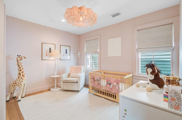 11 Francis St, Charleston, SC 29403 - bedroom featuring light wood finished floors, baseboards, recessed lighting, and a nursery area