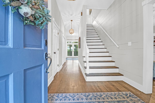 entrance foyer featuring hardwood / wood-style flooring and wood walls