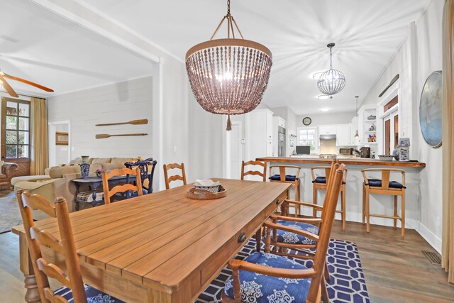 dining area featuring wood walls, dark hardwood / wood-style floors, and a notable chandelier