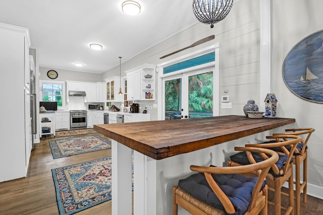 kitchen featuring wood counters, a breakfast bar, white cabinets, and kitchen peninsula