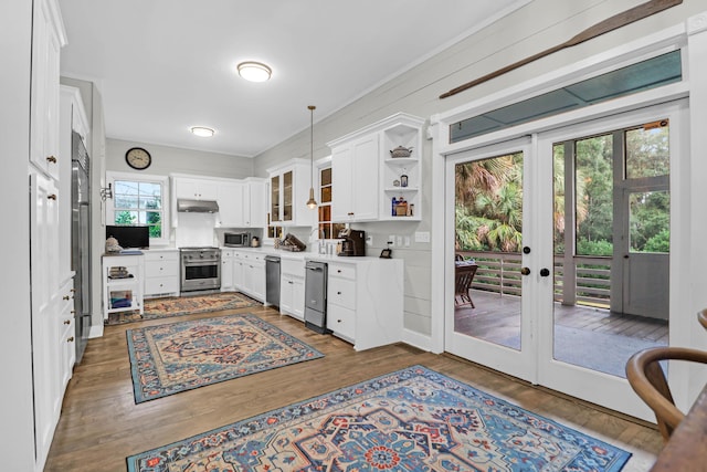 kitchen featuring premium appliances, plenty of natural light, white cabinetry, and french doors