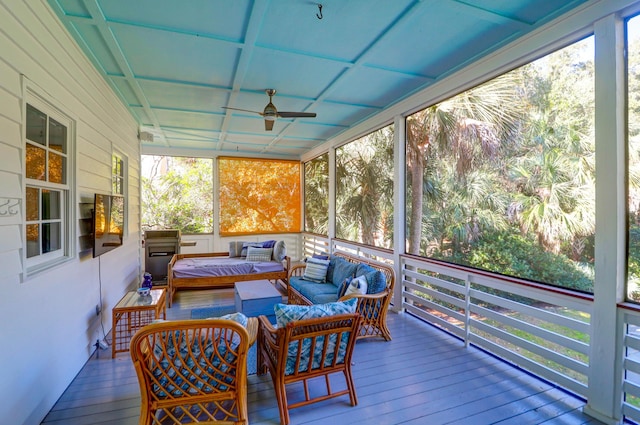 sunroom featuring ceiling fan and plenty of natural light