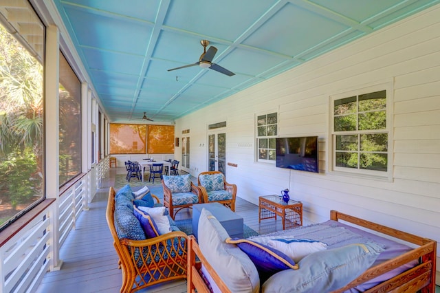 sunroom / solarium featuring vaulted ceiling, plenty of natural light, and ceiling fan