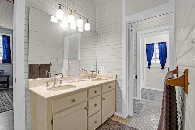 bathroom featuring tile patterned floors, vanity, and wooden walls