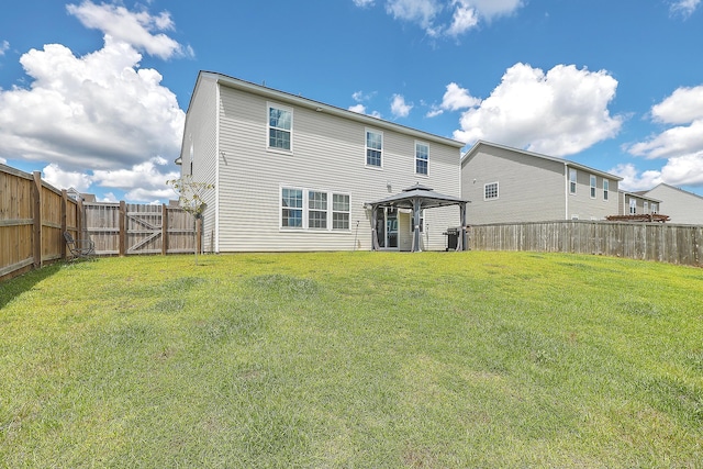 back of property with a gazebo and a yard