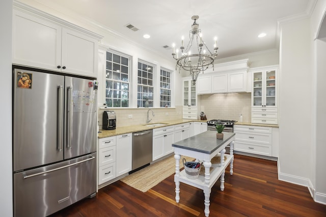 3221 Johnstowne St, Johns Island, SC 29455 - kitchen featuring appliances with stainless steel finishes, a chandelier, decorative backsplash, white cabinetry, and crown molding