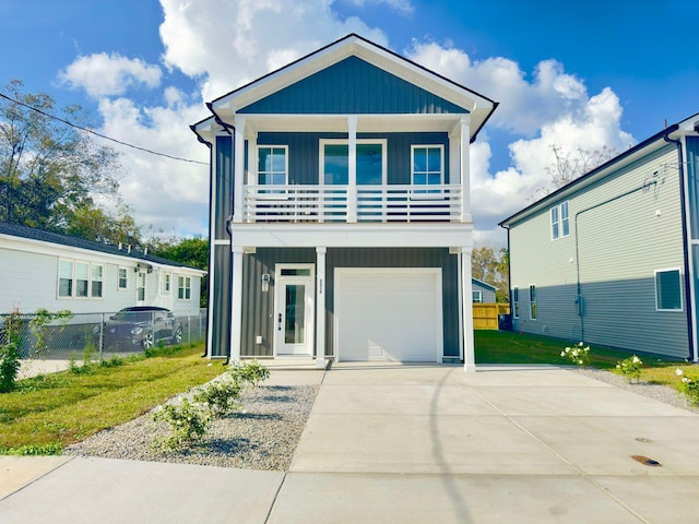 view of property with a balcony, a front lawn, and a garage