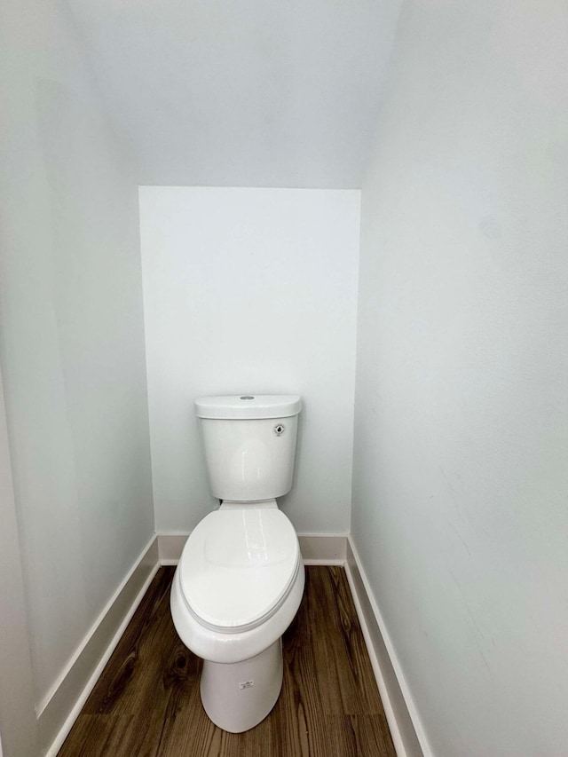 bathroom with hardwood / wood-style flooring and toilet