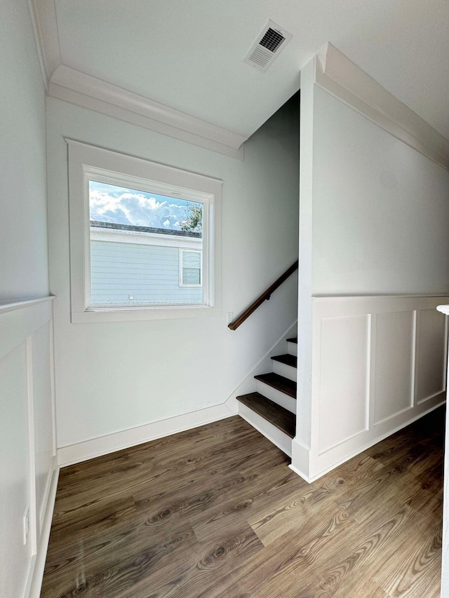 stairs with hardwood / wood-style floors and ornamental molding