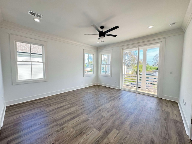 empty room with crown molding, ceiling fan, and dark wood-type flooring