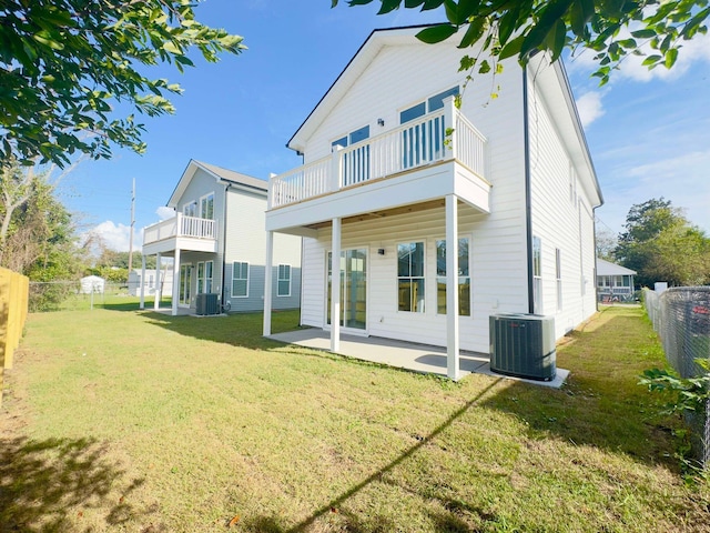 rear view of house featuring a lawn, a balcony, a patio, and central AC