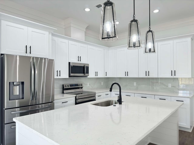 kitchen with white cabinets, appliances with stainless steel finishes, pendant lighting, and sink