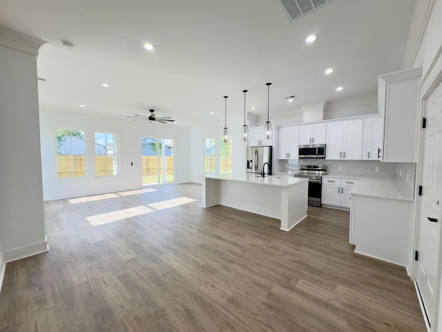 kitchen featuring white cabinetry, an island with sink, hardwood / wood-style flooring, and appliances with stainless steel finishes