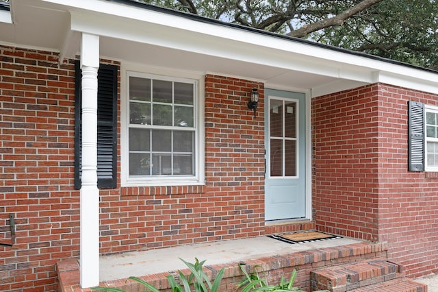 view of exterior entry featuring covered porch