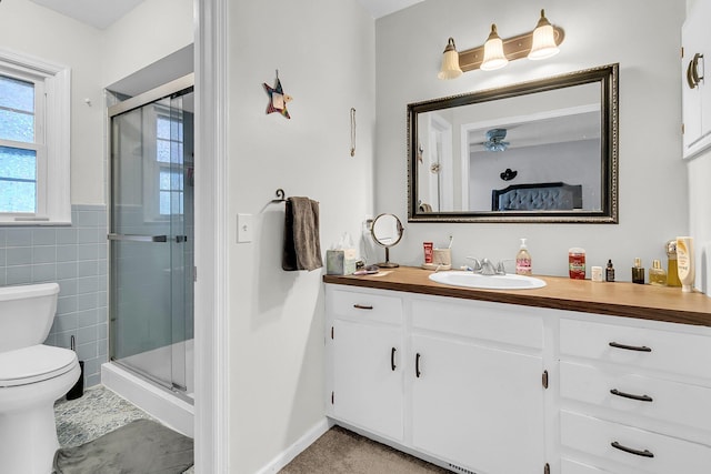 bathroom featuring vanity, a shower with shower door, and toilet