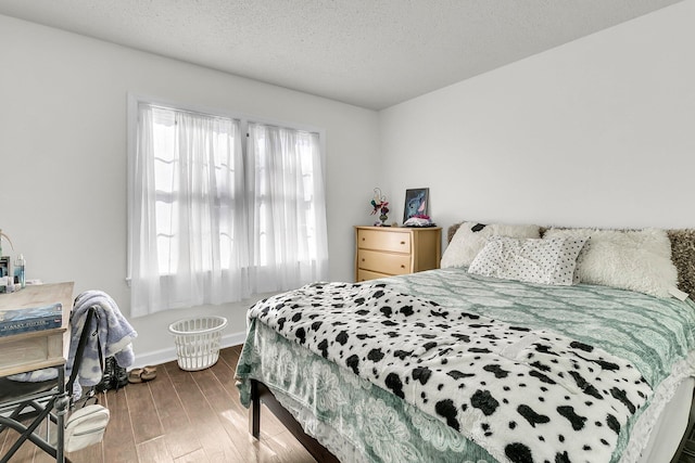 bedroom with hardwood / wood-style floors and a textured ceiling