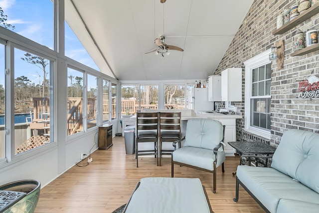 sunroom featuring ceiling fan, a healthy amount of sunlight, and lofted ceiling