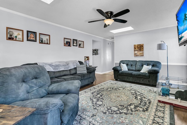 living room with ceiling fan, crown molding, dark hardwood / wood-style floors, and a skylight