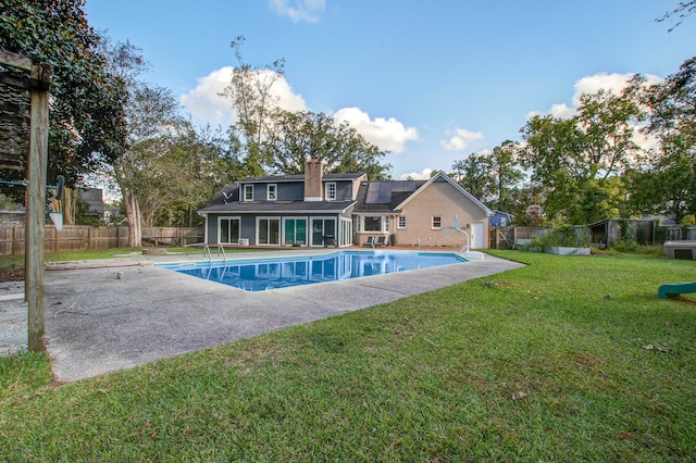 view of pool with a patio area and a yard