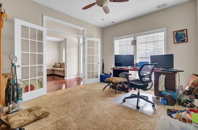 carpeted office space with french doors, visible vents, and ceiling fan