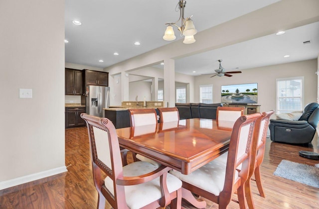 dining space with recessed lighting, baseboards, visible vents, light wood-style flooring, and ceiling fan with notable chandelier