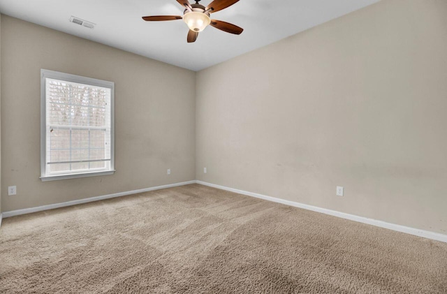 empty room with carpet, visible vents, baseboards, and ceiling fan