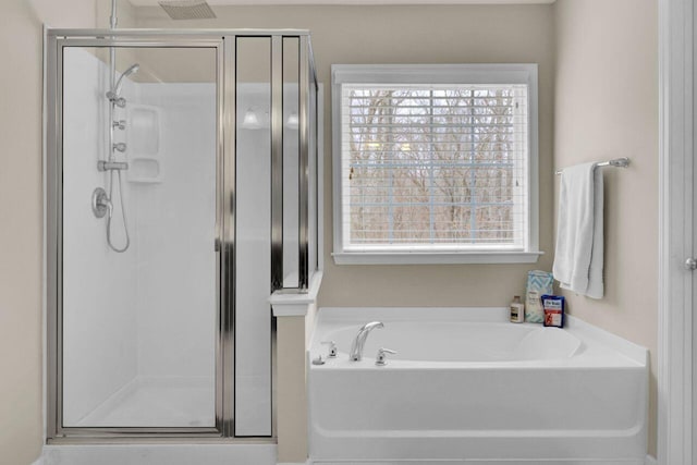 bathroom with a stall shower and a garden tub