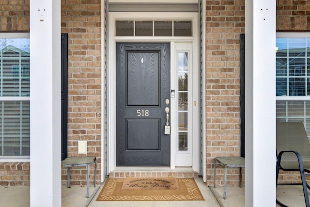 view of exterior entry with brick siding