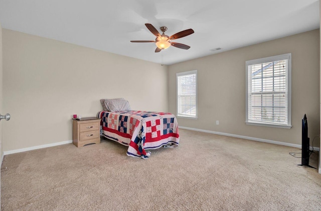 carpeted bedroom with visible vents, baseboards, and ceiling fan