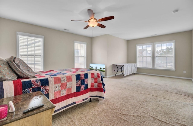 carpeted bedroom with visible vents, a ceiling fan, and baseboards