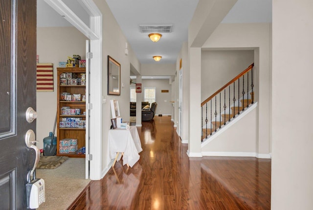 foyer with baseboards, stairs, visible vents, and wood finished floors