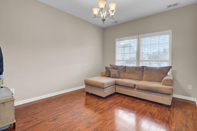 living room featuring a chandelier, wood finished floors, visible vents, and baseboards