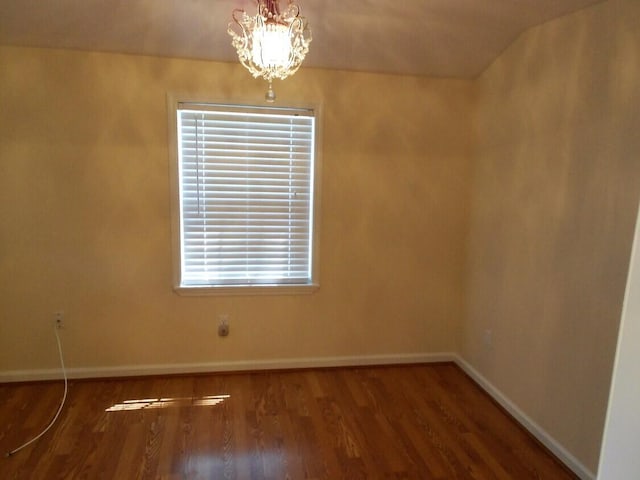 unfurnished room with wood-type flooring and a notable chandelier